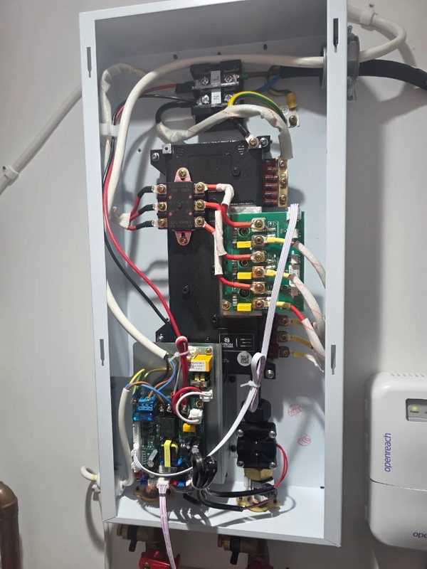 Internal view of a Strom electric boiler showing the heating element connections, control board and wiring