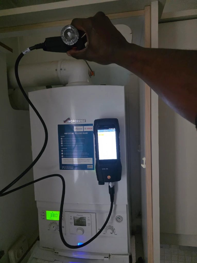 Engineer carrying out a flue gas analysis on a Worcester boiler using a testo combustion analyser