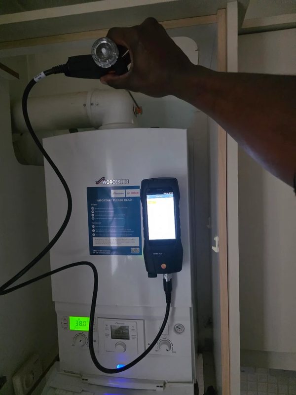 Engineer carrying out a flue gas analysis on a Worcester boiler using a testo combustion analyser