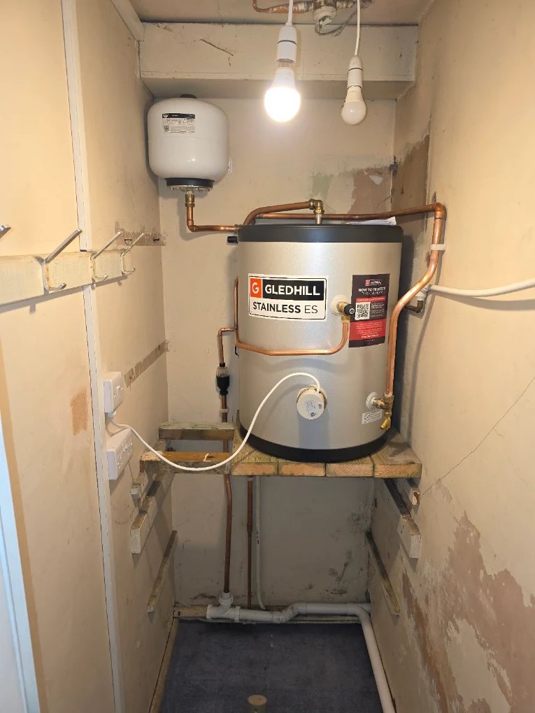 Gledhill Stainless unvented hot water cylinder installed on a platform with neat copper pipework and expansion vessel