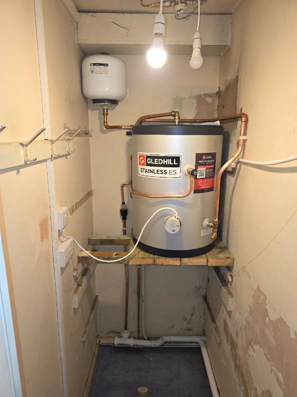 Gledhill Stainless unvented hot water cylinder installed on a platform with neat copper pipework and expansion vessel